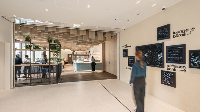 Über das einladende Foyer gelangen Kund:innen, Besucher:innen und Mitarbeiter:innen in die Bankfiliale, zu den Büros, ins Café und in den Veranstaltungsbereich. © M.O.O.CON / Hertha Hurnaus