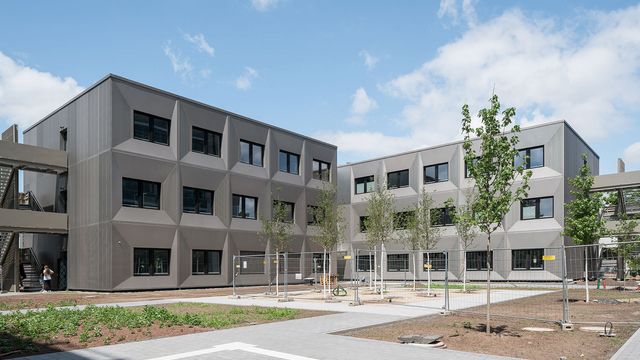 Das neue Gebäude gliedert sich in den Bestand ein, hebt sich aber in der Gestalt deutlich ab. Foto © Grüninger Architekten